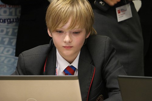 Student concentrating on a laptop during the cyber security challenge.
