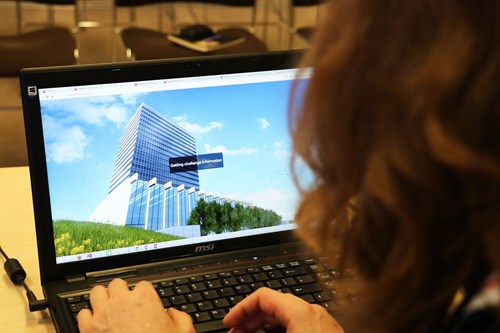 Participant viewing a virtual skyscraper in a cyber security game on a laptop.